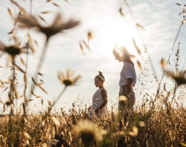 beautiful-young-mother-and-her-daughter-having-fun-at-the-field-chamomile-on-foreground-silhouettes_t20_OJZl0O